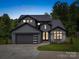 Stunning two-story home with gray siding, black accents, a modern garage door, and lush landscaping at 8039 Mcconnell Rd, Denver, NC 28037