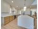 Open kitchen featuring stainless steel appliances, custom cabinets, and large center island with modern lighting at 8039 Mcconnell Rd, Denver, NC 28037