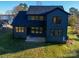 Exterior elevation of the home showcasing the dark siding, multiple windows and large, grassy backyard at 8039 Mcconnell Rd, Denver, NC 28037