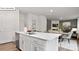 Modern kitchen island with white cabinets, stylish faucet, and open view to the living area at 108 Rustling Waters Dr, Mooresville, NC 28117