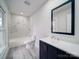 Modern bathroom with marble shower, white toilet, and dark vanity at 221 Palmer St, Albemarle, NC 28001