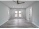 Spacious bedroom with ceiling fan, gray flooring, and access to the backyard at 221 Palmer St, Albemarle, NC 28001