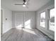 Bright bedroom with wood-look floors, ceiling fan, and ample window light at 221 Palmer St, Albemarle, NC 28001