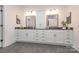 A modern bathroom with dual vanities, white cabinets, gray countertop, and decorative mirrors at 3013 Old Glory Dr # 24, Gastonia, NC 28056