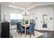 Bright dining area with a wooden table, blue chairs, large windows, and modern chandelier at 3013 Old Glory Dr # 24, Gastonia, NC 28056