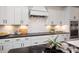 Close-up of modern kitchen with white cabinets, black countertops, subway tile backsplash, and stainless steel appliances at 3013 Old Glory Dr # 24, Gastonia, NC 28056