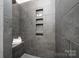 Modern shower with a dark gray tile surround, shower bench, and built in shower niches at 3013 Old Glory Dr # 24, Gastonia, NC 28056