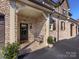 Front entry of townhome with brick facade, covered porch, and bench at 3364 Northampton Dr, Charlotte, NC 28210