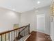 Upstairs hallway with hardwood floors and a view of a bathroom at 3364 Northampton Dr, Charlotte, NC 28210