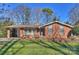 Brick ranch house with a landscaped lawn and driveway at 4017 Sulkirk Rd, Charlotte, NC 28210