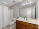 Clean bathroom with a tub, toilet and vanity with wooden cabinets at 500 Planters Way, Mount Holly, NC 28120