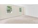 Bright, carpeted bedroom with neutral walls and natural light from two windows at 9106 Nash Ave, Charlotte, NC 28213