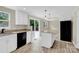 Bright kitchen features an island, stainless steel appliances, granite countertops, and deck access at 9106 Nash Ave, Charlotte, NC 28213