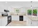 Modern kitchen boasts granite countertops, stainless appliances, and sliding door access to the deck at 9106 Nash Ave, Charlotte, NC 28213