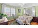 Bedroom with light green walls, hardwood floors, and a comfortable bed at 129 Ann St, Salisbury, NC 28146