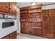 Kitchen boasts wood cabinets, built-in oven, and extra shelving at 129 Ann St, Salisbury, NC 28146