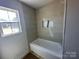 A well-lit bathroom featuring neutral tiling, a niche, and a window at 184 Maplewood Ln, Taylorsville, NC 28681