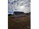 Side view of new home construction, partially covered, in a rural landscape at 184 Maplewood Ln, Taylorsville, NC 28681