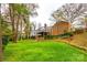 Spacious backyard featuring mature trees, a brick house, and a charming deck perfect for outdoor relaxation at 3319 Mill Pond Rd, Charlotte, NC 28226
