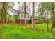 Lush backyard with stepping stone staircase leading to a sunroom and deck, surrounded by mature trees at 3319 Mill Pond Rd, Charlotte, NC 28226