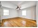 Inviting bedroom with hardwood floors, ceiling fan, and dual windows, offering a cozy retreat at 3319 Mill Pond Rd, Charlotte, NC 28226