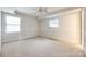 Neutral bedroom featuring carpet, a ceiling fan, and two windows at 3319 Mill Pond Rd, Charlotte, NC 28226