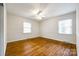 Bright bedroom with hardwood floors, ceiling fan, and two windows, offering a comfortable and inviting space at 3319 Mill Pond Rd, Charlotte, NC 28226
