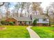 Charming split-level home featuring a well-manicured lawn, inviting walkway, and a mix of brick and siding at 3319 Mill Pond Rd, Charlotte, NC 28226