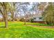 A beautiful tree-lined street featuring a well-maintained lawn, mature trees, and charming curb appeal at 3319 Mill Pond Rd, Charlotte, NC 28226