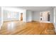 Open-concept living area featuring hardwood floors, fresh white paint, and access to foyer and dining spaces at 3319 Mill Pond Rd, Charlotte, NC 28226