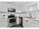 Updated kitchen with stainless steel appliances and white shaker cabinets at 353 Lee St, Mooresville, NC 28115