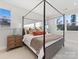 Bright bedroom featuring a four-poster bed with stylish bedding and a bedside table by the window at 8005 Elevate Ct, Charlotte, NC 28205