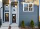 New construction exterior showing 2 townhome front doors, with a dark metal fence and small evergreen bushes at 8005 Elevate Ct, Charlotte, NC 28205