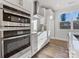 Kitchen featuring stainless appliances, white cabinets, quartz counters, hardwood floors and subway tile backsplash at 8005 Elevate Ct, Charlotte, NC 28205