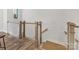 Staircase featuring hardwood floors, light wood posts, and white wood railings at 8005 Elevate Ct, Charlotte, NC 28205