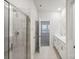 Bright bathroom featuring double sinks, a glass-enclosed shower, and neutral tile flooring at 1531 Harper Landing Blvd, Stanley, NC 28164
