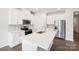 Modern kitchen with stainless steel appliances, white cabinetry, quartz countertops and center island at 1531 Harper Landing Blvd, Stanley, NC 28164