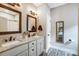 Double vanity bathroom with granite countertops and dark framed mirrors at 226 Hickory St, Locust, NC 28097