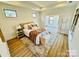 Sunlit bedroom with hardwood floors, bench, and a view to the living area at 409 Newstyle Way # 3, Cramerton, NC 28056