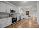 Well-lit kitchen featuring white cabinets, stainless steel appliances, granite countertops, and hardwood floors at 4759 Mel Nunnery Rd, Fort Lawn, SC 29714