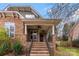 Inviting front porch with stone steps, decorative columns, and outdoor ceiling fans at 7708 Spanish Oaks Dr, Waxhaw, NC 28173