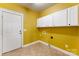 Laundry room with white cabinets, yellow walls, and tile floor at 7708 Spanish Oaks Dr, Waxhaw, NC 28173