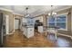 Modern kitchen with white cabinets, granite island and hardwood floors at 7721 Sedgebrook E Dr, Stanley, NC 28164