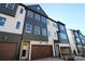 Modern 3-story townhome with dark gray and white exterior, 2-car garage, and landscaping at 7932 Cedarsmith Ct, Charlotte, NC 28217