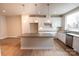 Bright kitchen featuring a center island, white cabinets, and wood look floors at 7932 Cedarsmith Ct, Charlotte, NC 28217