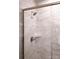 Close up of shower with marble tile and bronze hardware at 7932 Cedarsmith Ct, Charlotte, NC 28217