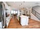 Open concept kitchen with island and view into living area at 8008 Cedarsmith Ct, Charlotte, NC 28217