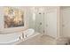 Luxurious bathroom with a soaking tub, glass shower, and a large window at 9042 Summer Club Rd, Charlotte, NC 28277