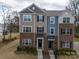 Three-story brick townhome with tan and blue siding, and a front walkway at 12024 John Newton Dr # 41, Davidson, NC 28036