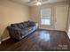 Living room with dark hardwood floors and gray couch at 1206 N Boyce St, Gastonia, NC 28052